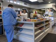 Salario mínimo de Connecticut subirá a $17.48 por hora en 2027 Trabajadora entregando un recibo en un comercio, imagen representativa de trabajadores por hora