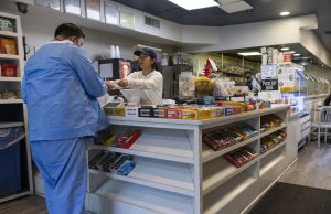 Salario mínimo de Connecticut subirá a $17.48 por hora en 2027 Trabajadora entregando un recibo en un comercio, imagen representativa de trabajadores por hora